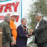 Borough Mayor Charlie Pierce (right) and Tim Navarre (far left) present an award to Will and Jane Madison for their work on the annual Industry Appreciation Day event on Saturday, Aug. 25, 2018 in Kenai, Alaska. (Photo by Elizabeth Earl/Peninsula Clarion)