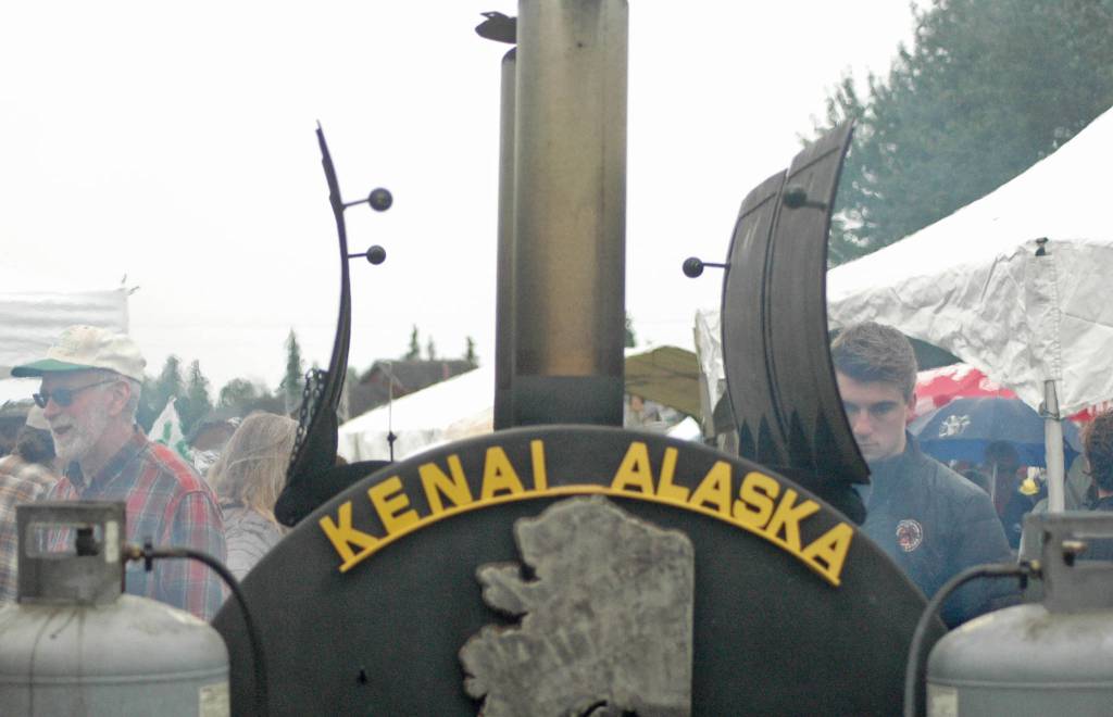 A communal grill emits smoke while people wait for lunch at the annual Industry Appreciation Day event on Saturday, Aug. 25, 2018 in Kenai, Alaska. (Photo by Elizabeth Earl/Peninsula Clarion)