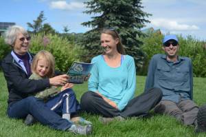 Janet Klein, left, holds her grandson, Sylas Reising, 4, while she visits with her daughter, Deborah Klein, center, and son-in-law George Reising, right, at Bishops Beach, Homer, Alaska, on Aug. 9, 2018. Not shown is Kai Reising, 6. Silas and Kai were the inspiration for the Kleins color and learn book, Alaskas Dinosaurs and Other Cretaceous Creatures.