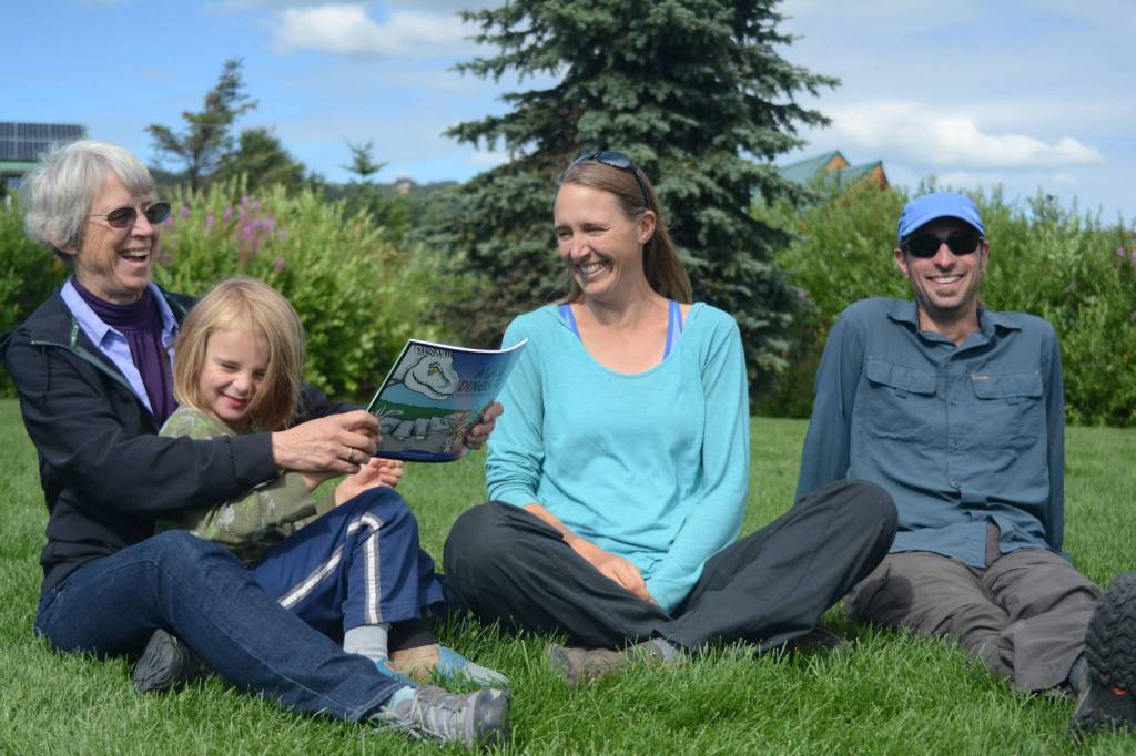 Janet Klein, left, holds her grandson, Silas Reising, 4, while she visits with her daughter, Deborah Klein, center, and son-in-law George Reising, right, at Bishops Beach, Homer, Alaska, on Aug. 9, 2018. Not shown is Kai Reising, 6. Sylas and Kai were the inspiration for the Kleins color and learn book, Alaskas Dinosaurs and Other Cretaceous Creatures.