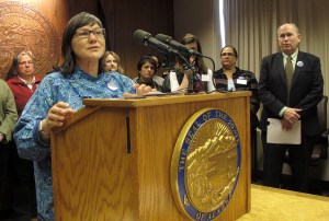 State Health Commissioner Valerie Davidson, left, speaks with reporters during a news conference as Gov. Bill Walker, far right, watches on Tuesday, March 17, 2015, in Juneau, Alaska. Walker announced plans to introduce legislation to reform and expand the Medicaid system in Alaska.