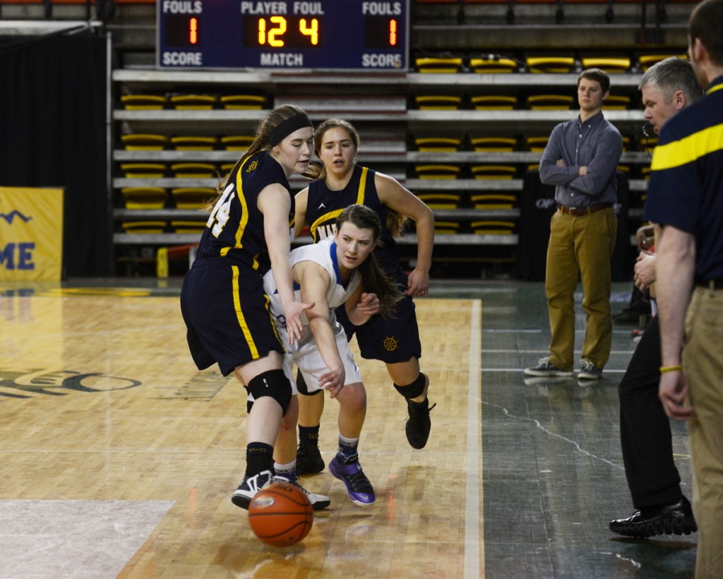 Homer juniors Madison Akers (front) and Aurora Waclawski trap an ACS player against the sidelines in Friday's matchup against the Lions at the Sullivan Arena. Homer lost 34-23.