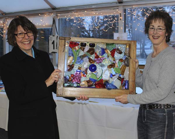 Mary Krull & Mary Green display a donated auction item.