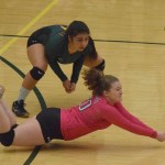 Seward libero Kimmie Hubbard (in pink) digs for a ball with teammate Tia Miranda, Friday against Monroe Catholic in the Class 3A state volleyball tournament held at the Alaska Airlines Arena in Anchorage.