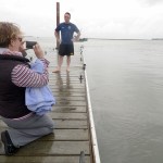 Jessica Bookey films her firefighter husband Terry Bookey as he prepares to jump off of the Kenai City Dock as part of a Cold Water Challenge for charity in Kenai, Alaska.