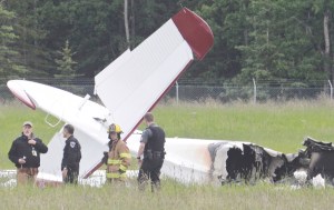 In this July 7, 2013 file photo investigators look at the remains of a fixed-wing aircraft that was engulfed in flames  at the Soldotna Airport in Soldotna, Alaska. No survivors were located. Ten people died in the the crash.