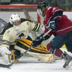 Kenai River Brown Bears goaltender Robbie Goor tries to poke the puck away from Fairbanks Ice Dogs forward Cayden Cahill on Thursday, Feb. 2, 2017, at the Soldotna Regional Sports Complex. (Photo by Jeff Helminiak/Peninsula Clarion)