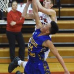 Kenai Central&rsquo;s Josh Jackman lays in a shot over Kodiak defender Roberto Giron, Friday night at Kenai Central High School. (Photo by Joey Klecka/Peninsula Clarion)