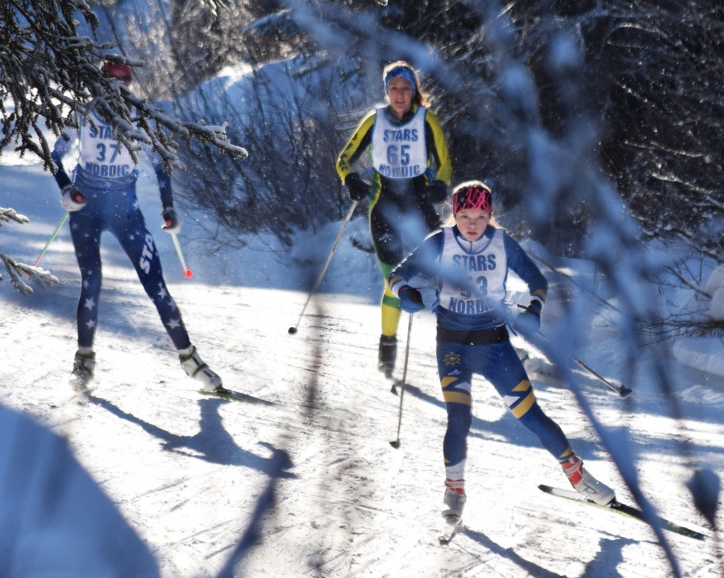 Homer skier Katie Davis (53) leads Sadie Lindquist of Seward and Soldotna&rsquo;s Kellie Arthur in Saturday&rsquo;s Kenai Peninsula Borough girls race on the Tsalteshi Trails. (Photo by Joey Klecka/Peninsula Clarion)