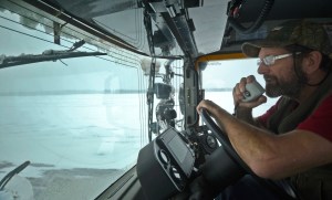 Equipment operator Terry Russ drives a broom machine up and down the runway of the Kenai Municipal Airport on Monday, Feb. 13, 2017 in Kenai, Alaska. Russ had been at work since 4 a.m doing what he called &ldquo;probably the most monotonous job on the airport&rdquo; to keep the runway clear of snow that could soldify into ice. On heavy snow days, two broom machines drive down each side of the runway centerline, whirling away snow with heavy rotary brushes while a plow truck scrapes off packed snow and ice. (Ben Boettger/Peninsula Clarion)