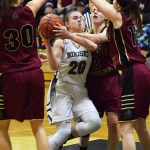 Nikiski guard Bethany Carstens (20) works to find a way through a horde of Grace Christian defenders Friday night at Nikiski High School. (Photo by Joey Klecka/Peninsula Clarion)