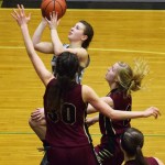 Nikiski&rsquo;s Kelsey Clark looks to the rim against Grace Christian defenders Sarah Laker (30) and Annie VanderWeide, Friday at Nikiski High School. (Photo by Joey Klecka/Peninsula Clarion)