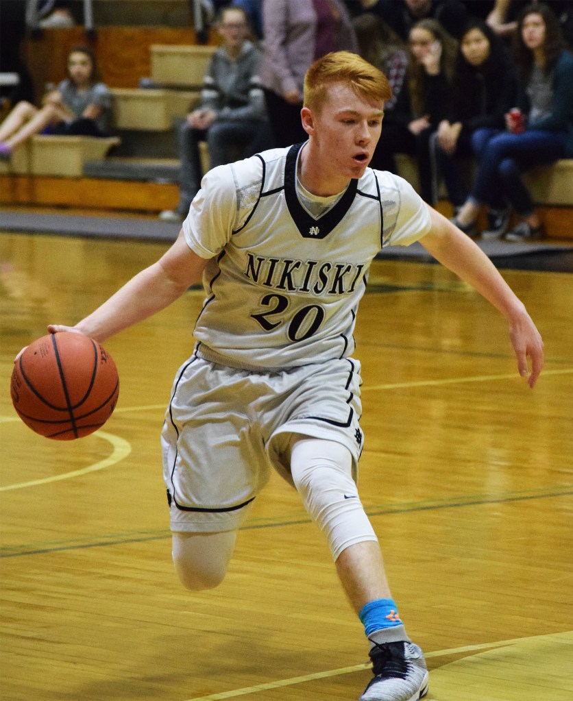 Nikiski guard Jace Kornstad dribbles the ball up the floor Friday night against Grace Christian. (Photo by Joey Klecka/Peninsula Clarion)