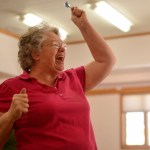 Bonnie Cain, an organizer of the 13th annual Kenai Peninsula Senior Olympics, reacts after scoring a hit during the Senior Olympics darts competition on Wednesday, Feb. 22, 2017 at the Soldotna Senior Center in Soldotna, Alaska. The competition was the first time Cain had played darts. &ldquo;They talked me into it,&rdquo; she said, of the friends playing with her.