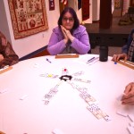 Ray Nickleson (left) and Donna Weaver watch Donna&rsquo;s husband Dick Weaver make a move in the dominoes competition of the 13th annual Kenai Peninsula Senior Olympics on Thursday, Feb. 23, 2017 at the Kenai Chamber of Commerce and Visitors Center in Kenai, Alaska.