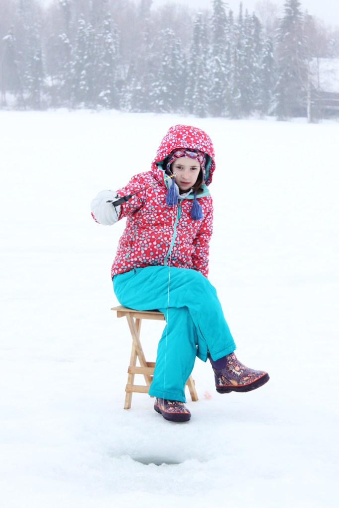 Kaleidoscope School of Arts and Sciences fourth grader Mya Taylor, 9, monitors her fishing line while trying to catch a fish during an outing Friday, Feb. 24, 2017 at Sport Lake in Soldotna, Alaska. The outing, along with two others in February, are part of the Alaska Department of Fish and Game "Salmon in the Classroom" program that hundreds of Kenai Peninsula School District students participate in each year. (Megan Pacer/Peninsula Clarion)
