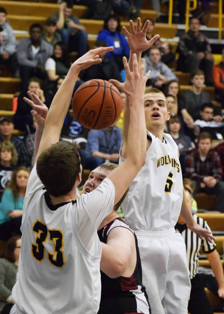 Ninilchik&rsquo;s Dalton Geppert (5) teams up with Austin White (33) to block the shot of Nikolaevsk&rsquo;s Anfim Kalugin in Friday&rsquo;s Peninsula Conference boys championship game at Homer High School. (Photo by Joey Klecka/Peninsula Clarion)