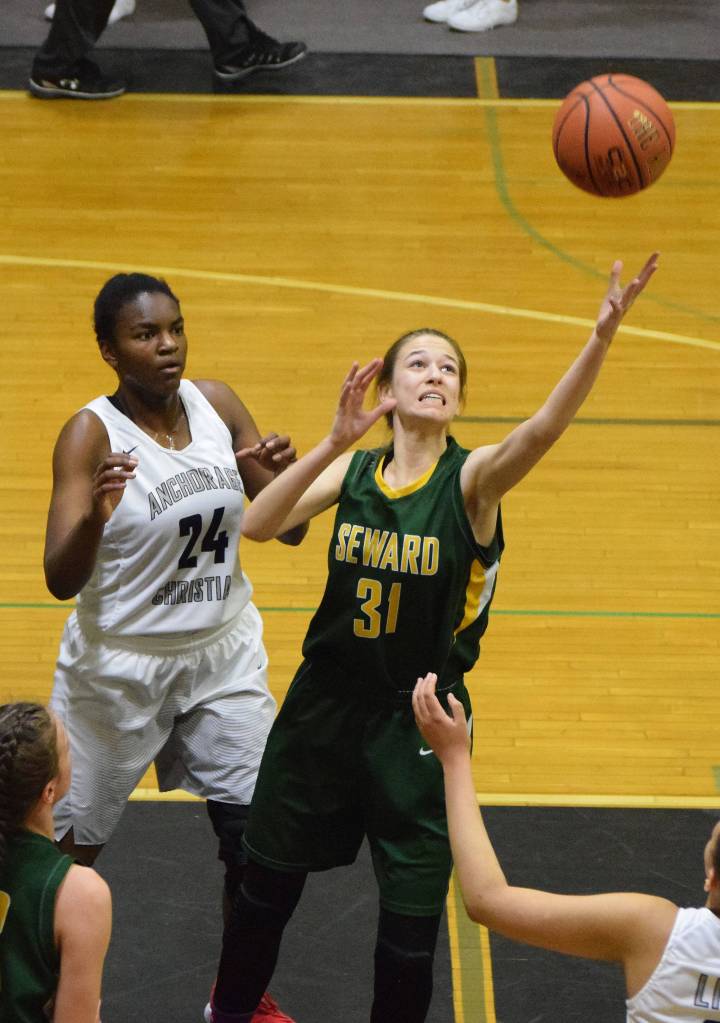 Seward&rsquo;s Madi Moore (31) reaches for a rebound above Anchorage Christian&rsquo;s Jordan Todd, Friday at the Southcentral Conference basketball tournament at Nikiski High School. (Photo by Joey Klecka/Peninsula Clarion)