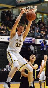 Ninilchik&rsquo;s Austin White puts down a two-handed dunk against the Aniak Halfbreeds Wednesday at the Class 1A state basketball tournament at the Alaska Airlines Center in Anchorage. (Photo by Joey Klecka/Peninsula Clarion)