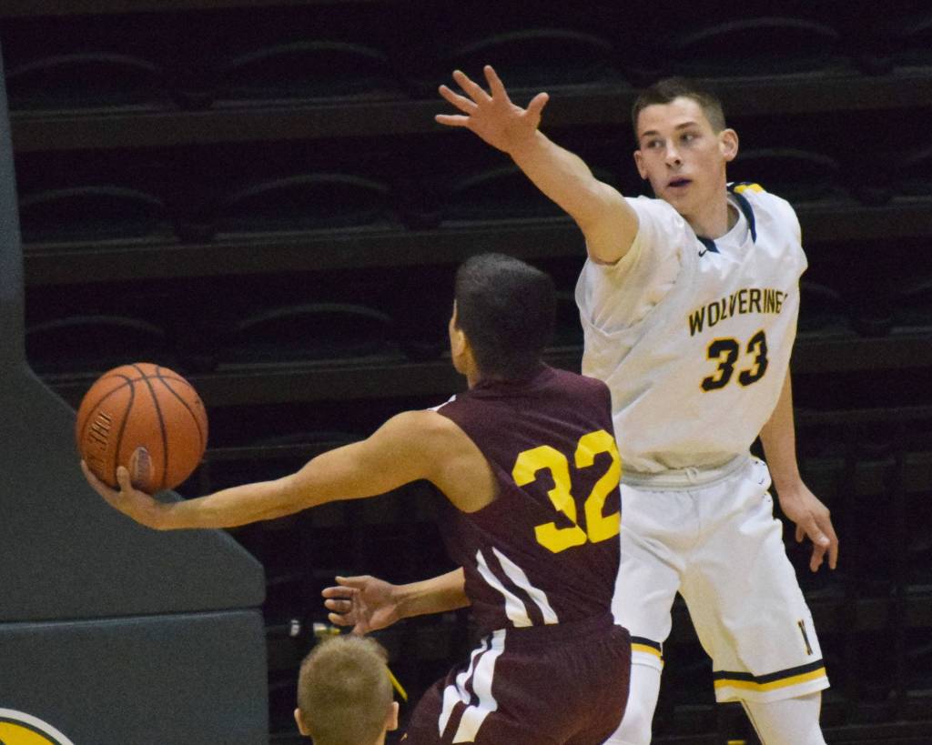 Ninilchik&rsquo;s Austin White (33) puts up a block on Shaktoolik&rsquo;s Everson Paniptchuk in Thursday, March 16, 2017, afternoon&rsquo;s Class 1A state basketball tournament semifinal at the Alaska Airlines Center in Anchorage. (Photo by Joey Klecka/Peninsula Clarion)