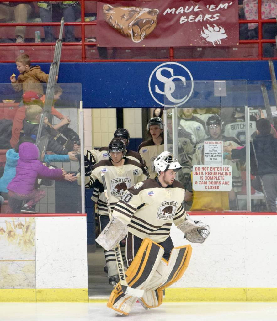 The Kenai River Brown Bears give young fans high-fives as goalie Robbie Goor leads them onto the ice for the third period Friday, March 24, 2017, at the Soldotna Regional Sports Complex. (Photo by Jeff Helminiak/Peninsula Clarion)