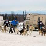 Two teams race to hook up their dogs after the shotgun start at Freddie&rsquo;s Midnight Run in Caribou Hills on Saturday, April 1. (Kat Sorensen/Peninsula Clarion)