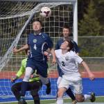 Homer defender Timothy Blakely (4) makes a saving header on a corner kick over Colony midfielder Kyle Dearborn (2) May 19, 2016, in a Northern Lights Conference tournament quarterfinal match at Justin Maile Field in Soldotna. (Photo by Joey Klecka/Peninsula Clarion)