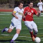 Kenai Central defender Max Dye (22) battles with South Anchorage&rsquo;s Blake Hepler April 16, 2016, at Ed Hollier Field in Kenai. (Photo by Joey Klecka/Peninsula Clarion)