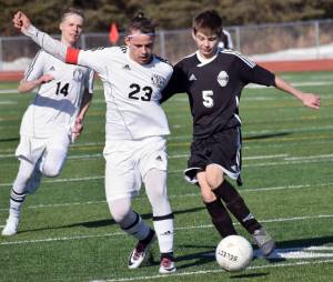 Kenai Central&rsquo;s Zack Tuttle and Nikiski&rsquo;s Mason Payne battle for the ball Wednesday, April 12, 2017, at Kenai Central High School. (Photo by Jeff Helminiak/Peninsula Clarion)