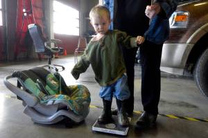 Orion Brandon, a 2-year-old from Sterling, visits the Kenai Fire Station for a free car-seat check up provided by Safe Kids Kenai Peninsula on Monday, April 17, 2017 in Kenai, Alaska. Jane Fellman, of Safe Kids and Central Peninsula Hospital, weighs Brandon to ensure he’s in the right size car seat. Safe Kids is offering another check on Wednesday from 12 to 2 p.m. at the Nikiski Fire Station. (Kat Sorensen/Peninsula Clarion)