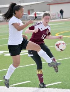 Kenai Central&rsquo;s Lexy Carrasco at Ketchikan&rsquo;s Cameron Edwards battle for the ball Wednesday, April 26, 2017, at Kenai Central High School. (Photo by Jeff Helminiak/Peninsula Clarion)