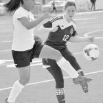 Kenai Central&rsquo;s Lexy Carrasco at Ketchikan&rsquo;s Cameron Edwards battle for the ball Wednesday at Kenai Central High School. (Photo by Jeff Helminiak/Peninsula Clarion)