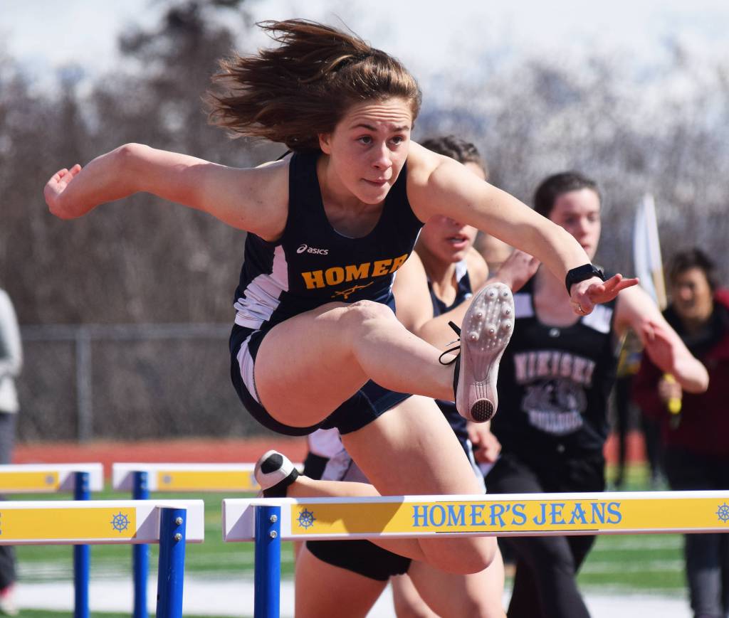 Homer senior Lauren Evarts leaps a barrier in the girls 100-meter hurdles race Saturday at the Homer Invite at Homer High School. (Photo by Joey Klecka/Peninsula Clarion)
