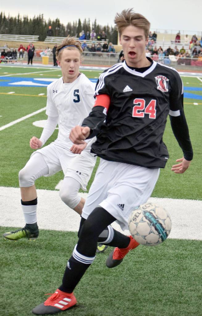 Kenai Central&rsquo;s Luke Beiser controls the ball in front of Soldotna&rsquo;s Luke Trammell on Tuesday at Soldotna High School. (Photo by Jeff Helminiak/Peninsula Clarion)