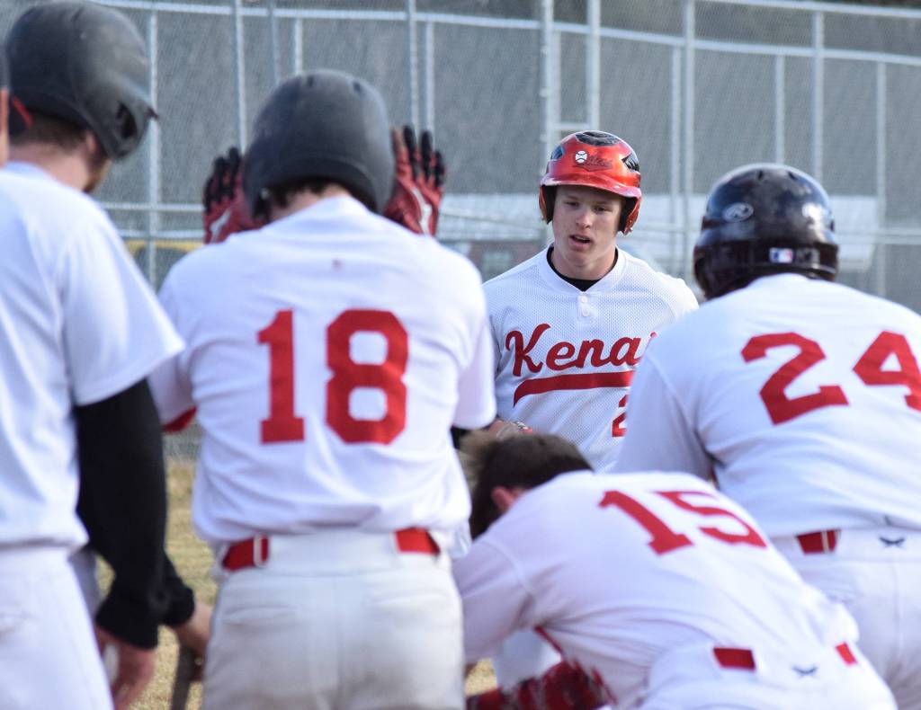 Kenai Central&rsquo;s Paul Steffensen approaches home plate amidst a throng of teammates after hitting a home run against Kodiak Thursday night at the Kenai Little League fields. (Photo by Joey Klecka/Peninsula Clarion)