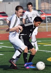 Kenai Central&rsquo;s Riley McKee (left) and Nikiski&rsquo;s Martin Cox battle for possession of the ball Friday afternoon at Ed Hollier Field in Kenai. (Photo by Joey Klecka/Peninsula Clarion)