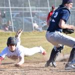 Kenai Central&rsquo;s Paul Steffensen dives for home plate behind Soldotna catcher Cody Quelland to score a run Wednesday evening at the Kenai Little League Fields. (Photo by Joey Klecka/Peninsula Clarion)