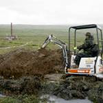 FILE - In this July 13, 2007 file photo, a worker with the Pebble Mine project digs in the Bristol Bay region of Alaska near the village of Iliamma, Alaska. The Trump administration settled a lawsuit Friday, May 12, 2017, over the proposed development of a massive copper and gold deposit near the headwaters of a world-premier salmon fishery in southwest Alaska. (AP Photo/Al Grillo,File)