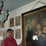 John Michael, a member of Kenai&rsquo;s Holy Assumption of the Virgin Mary Russian Orthodox Church, prepares to carry a damaged icon of Jesus praying in the Garden of Gethsemane from the church&rsquo;s sanctuary on Monday, May 15 in Kenai. In the foreground stands the wooden cross that fell backward during the January 2016 Iniskin Earthquake, tearing the icon&rsquo;s canvas. After planning and fundraising for the icon&rsquo;s repair since mid-2016, the church shipped it to an art restorer on Monday.