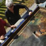 Holy Assumption Congregation members John Michael and Dorothy Grey (who is also secretary of the nonprofit Russian Orthodox Sacred Sites in America) inspect the Gethsmane icon as it lays in the back of a truck on Monday, May 15 outside Holy Assumption of the Virgin Mary Russian Orthodox church in Kenai. After leaving the church&rsquo;s sanctuary, the icon&rsquo;s next stop was a packaging store in Soldotna, where it was fitted into a custom box for shipment to an art conservator in Colorado. Grey estimated the cost to repair the icon at between $5,000 to $6,000, and said the precise cost would depend on the conservator&rsquo;s appraisal. Grey said the group has raised about half of the expected cost &mdash; $2,885, according to the icon repair project&rsquo;s crowdfunding webpage.
