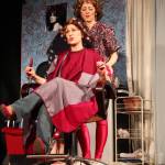 AnnMarie Rudstrom (front) and Cheri Johnson act out a scene from &ldquo;Steel Magnolias&rdquo; during the play&rsquo;s opening night Friday, May 12, 2017 at the Triumvirate Theatre north of Kenai, Alaska. The play will run again this weekend, at 7 p.m. Friday and Saturday. (Megan Pacer/Peninsula Clarion)