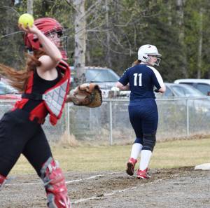 Soldotna&rsquo;s Tara Lynn Frates (11) takes a look behind as Kenai Central catcher Alyssa Stanton makes a throw to first base Wednesday at the Soldotna Little League Fields. (Photo by Joey Klecka/Peninsula Clarion)