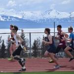 A group of boys race by a dazzling view of Kachemak Bay, April 29 at the Homer Invite at Homer High School. (Photo by Joey Klecka/Peninsula Clarion)