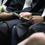 A graduate of Nikiski Middle-High School fidgets with his flower, which all the students carried, during the graduation ceremony Tuesday, May 23, 2017 at the school gymnasium in Nikiski, Alaska. (Megan Pacer/Peninsula Clarion)