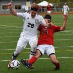 Kenai Central&rsquo;s Rykker Riddall (28) and Juneau-Douglas&rsquo; Ben Undurraga battle for possession in a quarterfinal meeting Thursday at the state soccer tournament at Eagle River High School. (Photo by Joey Klecka/Peninsula Clarion)