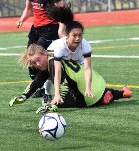 Dimond&rsquo;s Allison Shafer collides with Kenai Central goalkeeper Kailey Hamilton in a quarterfinal matchup Thursday at the state soccer tournament at Eagle River High School. (Photo by Joey Klecka/Peninsula Clarion)