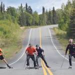 Soldotna sophomore Bradley Walters, Kenai Central junior Trevor Debnam and Soldotna sophomore Jack Harris pull tires up a hill on South Coho Loop under the watch of Andy Liebner on Monday.