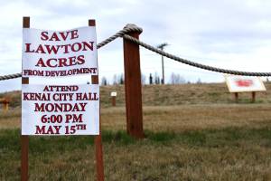 A sign posted near the Kenai Field of Flowers by activist and nieghborhood resident Greg Daniels urges property-owners near Lawton Acres &mdash; a 16.5-acre wooded strip of city-owned land that has been the subject of controversial development efforts &mdash; to attend a past Kenai City Council meeting, phographed on May 12, 2017 in Kenai, Alaska. The Kenai City Council may vote on June 21 or July 5 on whether to preserve Lawton Acres as a park by paying to relieve it from the legal obligation to support the Kenai Municipal Airport.
