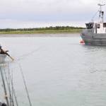 Bill Russell, a fishing guide at Russell Fishing Company, tows two fishing boats full of clients past a docked commercial fishing vessel on the Kasilof River on Monday, June 19, 2017 in Kasilof, Alaska. (Photo by Elizabeth Earl/Peninsula Clarion)