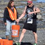Joshua Holley (354) carries a sand-filled bucket along the beach Saturday at the third annual Clam Scramble Mud Run in Ninilchik. (Photo by Joey Klecka/Peninsula Clarion)